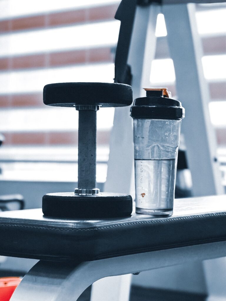 Shaker en dumbbell op een bankje in de sportschool