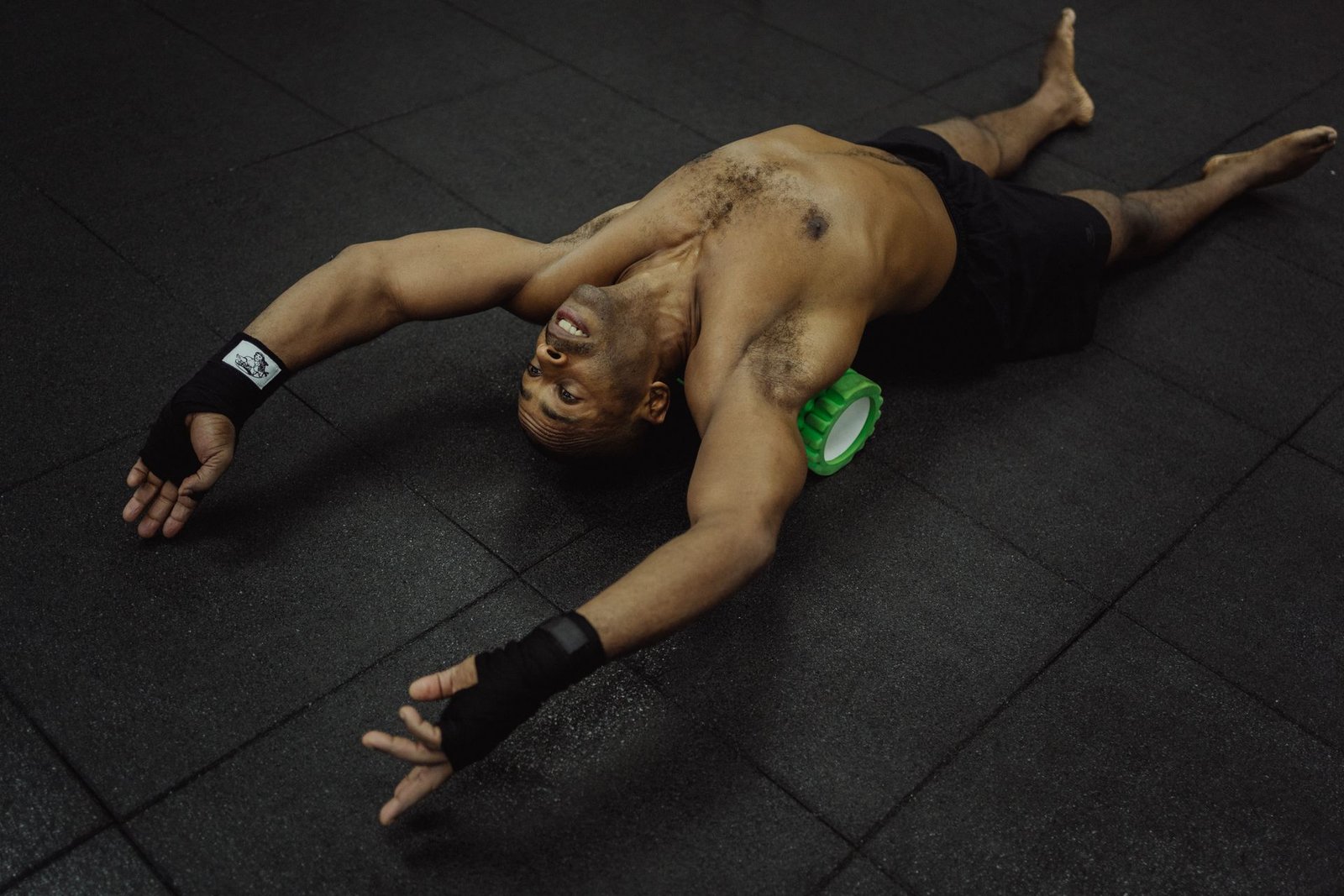 Man gebruikt een foam roller voor spierherstel in de sportschool
